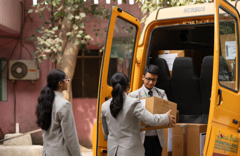 Students loading boxes of school supplies into a van