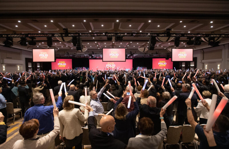 Rotary members raising End Polio Now light sticks at a convention